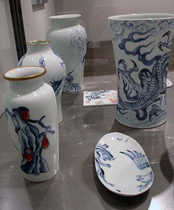 A table topped with vases and plates with dragons on them