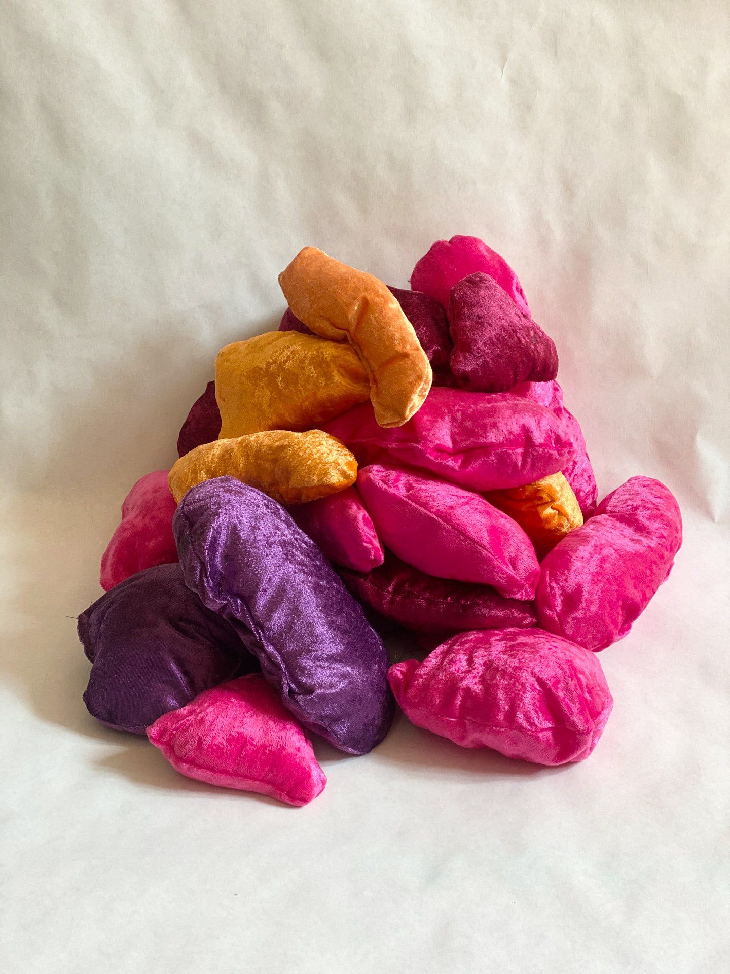 A pile of pink and purple pillows on a white surface