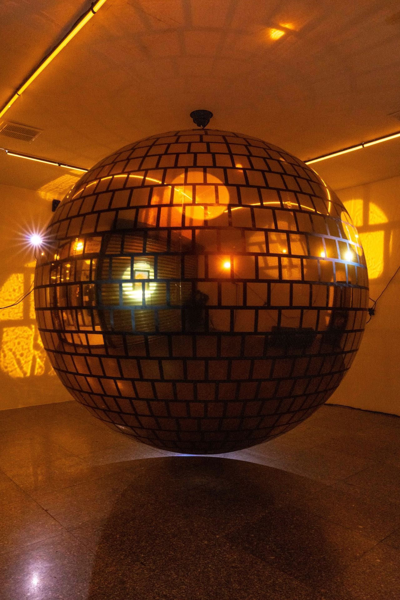 A large disco ball is hanging from the ceiling in a room