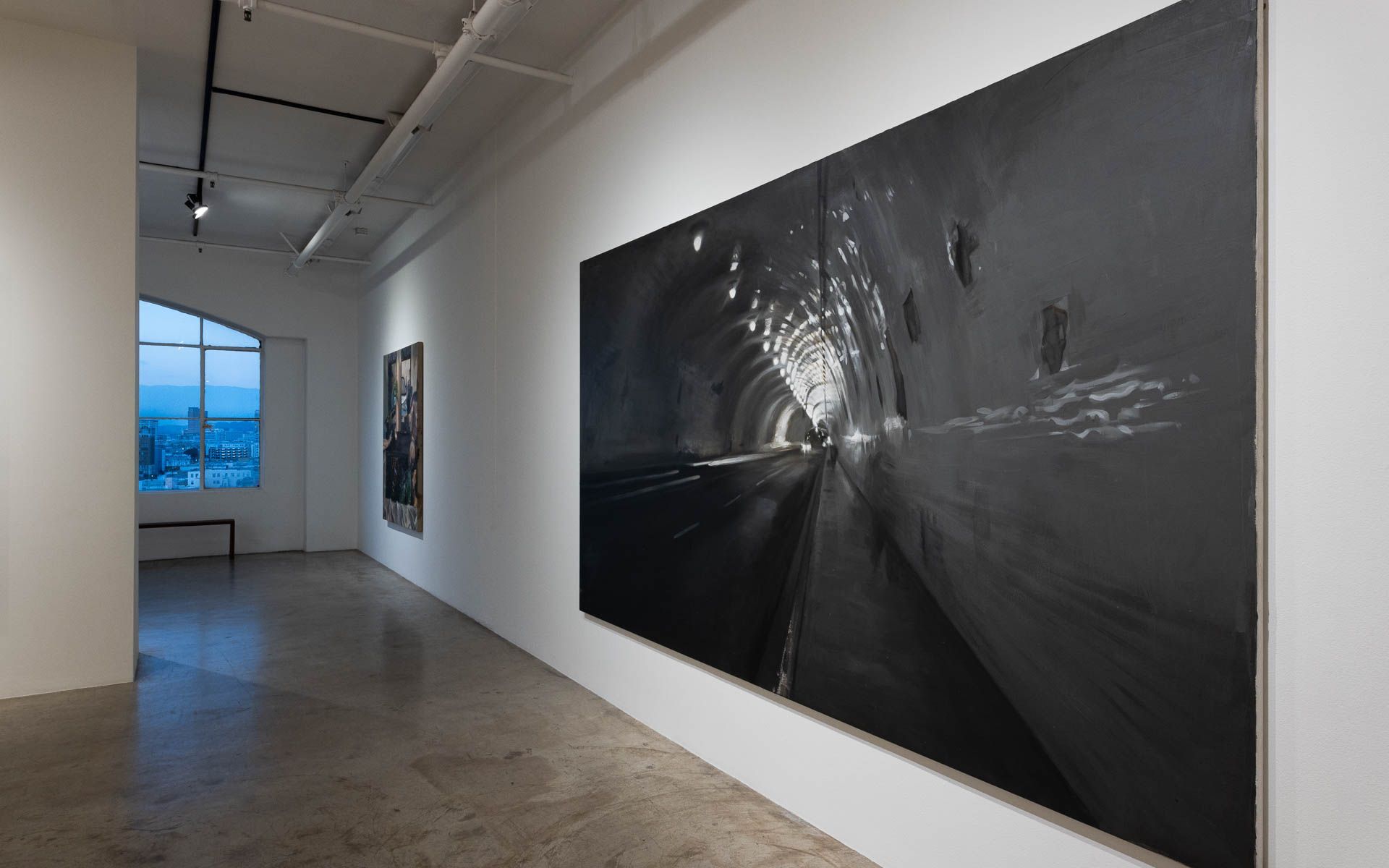 A large black and white painting is hanging on a white wall in Track 16 Gallery.