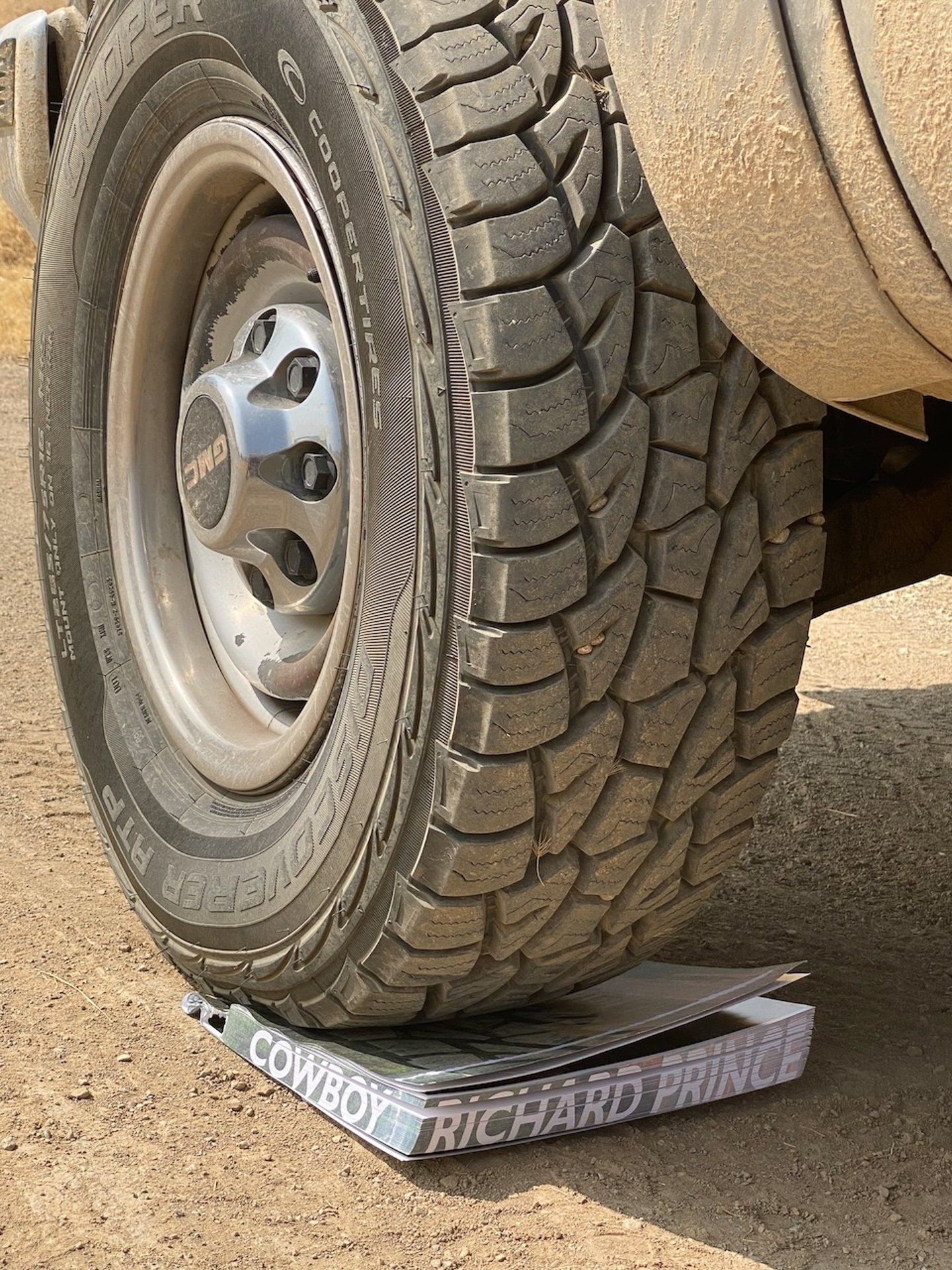 A tire is sitting on top of a box that says cowboy richard prince.