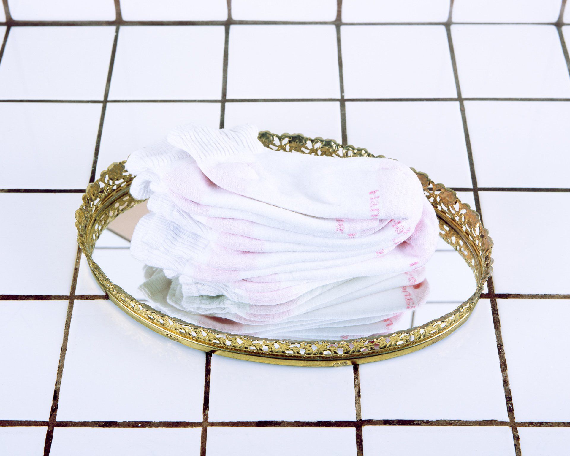 A gold tray with a stack of socks on it