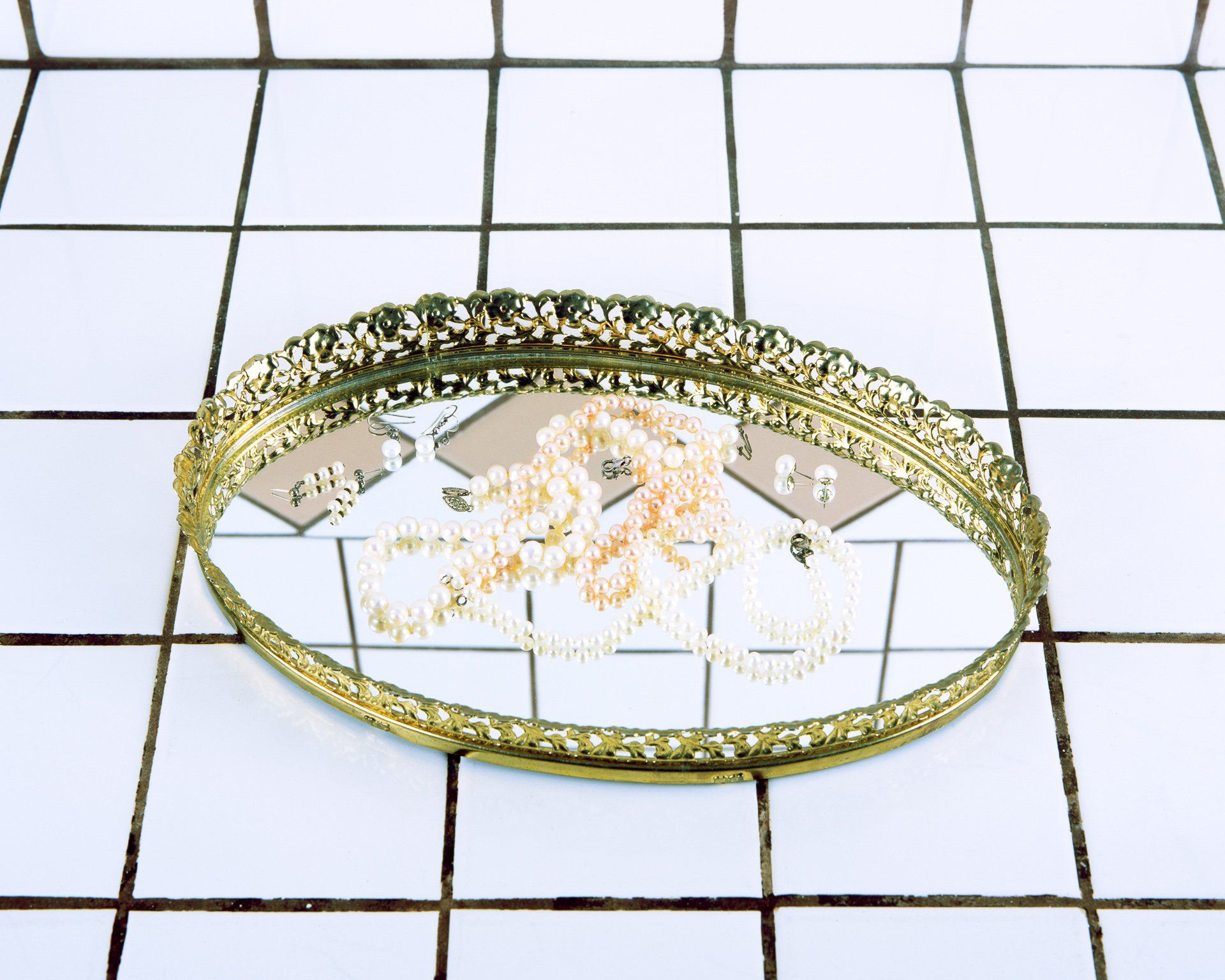 A gold tray with a necklace and earrings on it