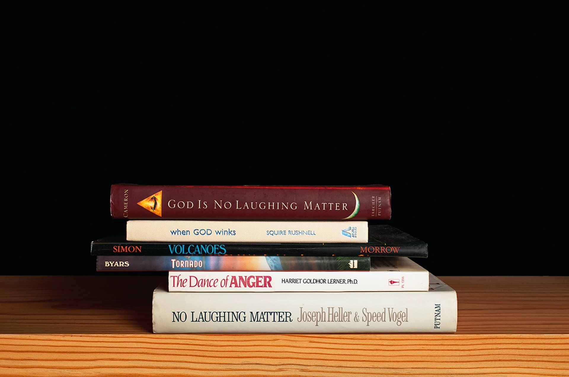 A stack of books sitting on top of each other on a wooden table.
