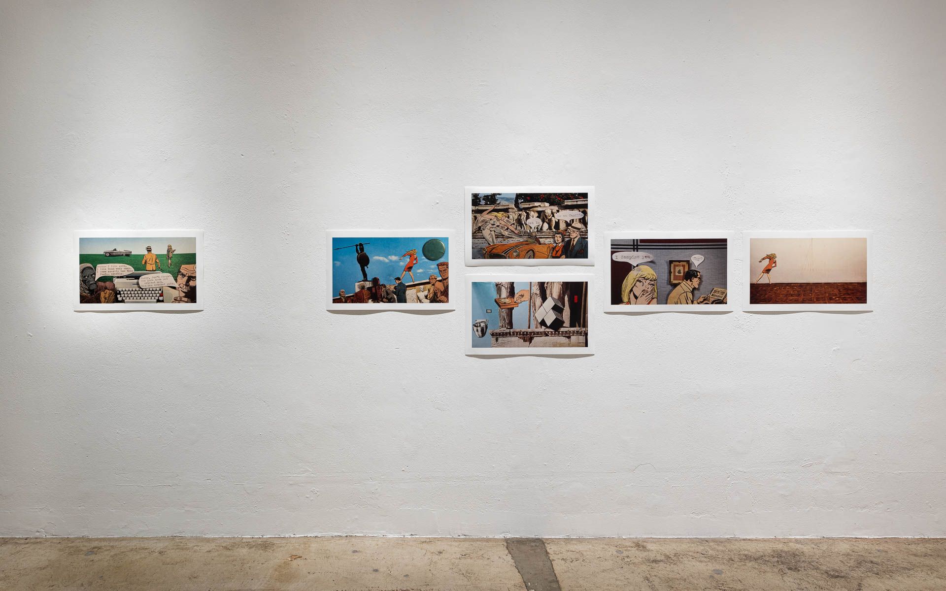A row of pictures are hanging on a white wall in a room.