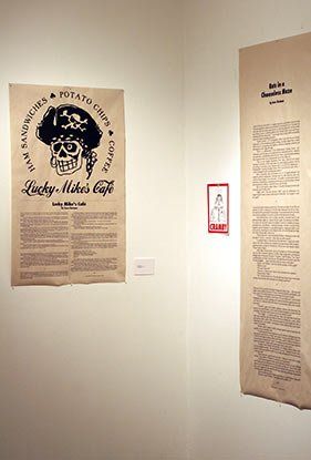 Two posters on a wall with one that says lucky water 's cafe