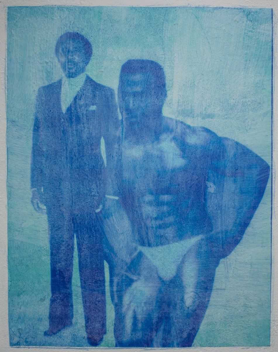 A man in a suit is standing next to a man in a bikini.