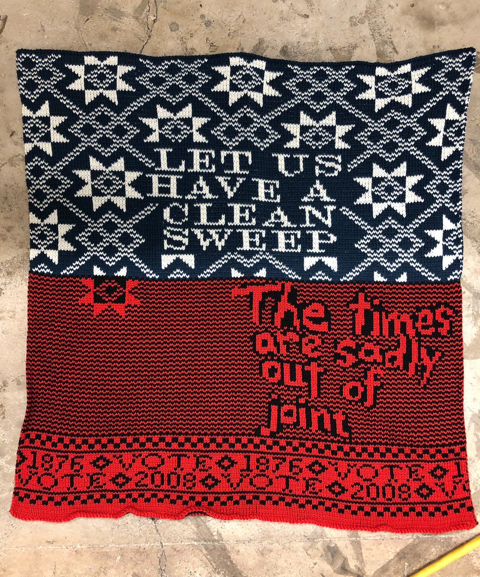 A piece of knitted fabric that says let us have a clean sweep