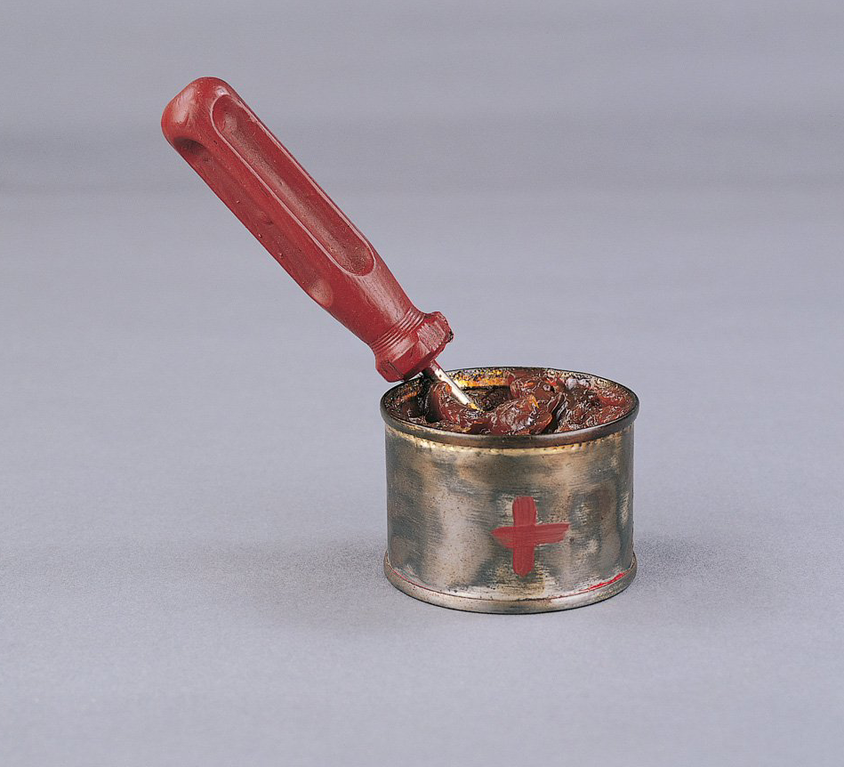 A can with a red cross on it and a spoon in it