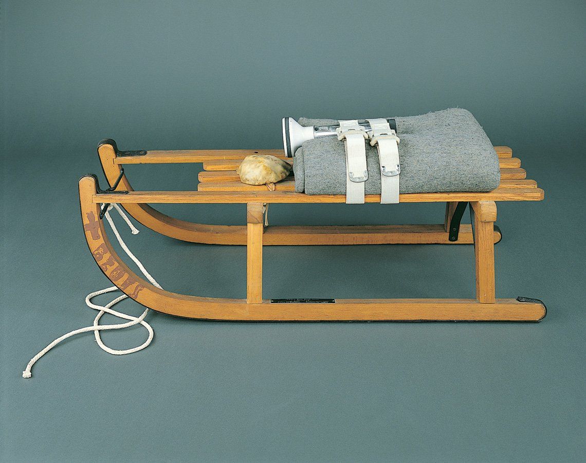 A wooden sled with a blanket on top of it