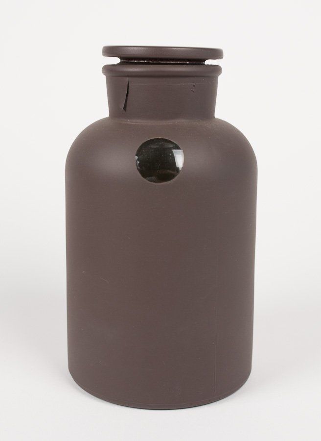 A brown vase with a hole in the middle on a white background.