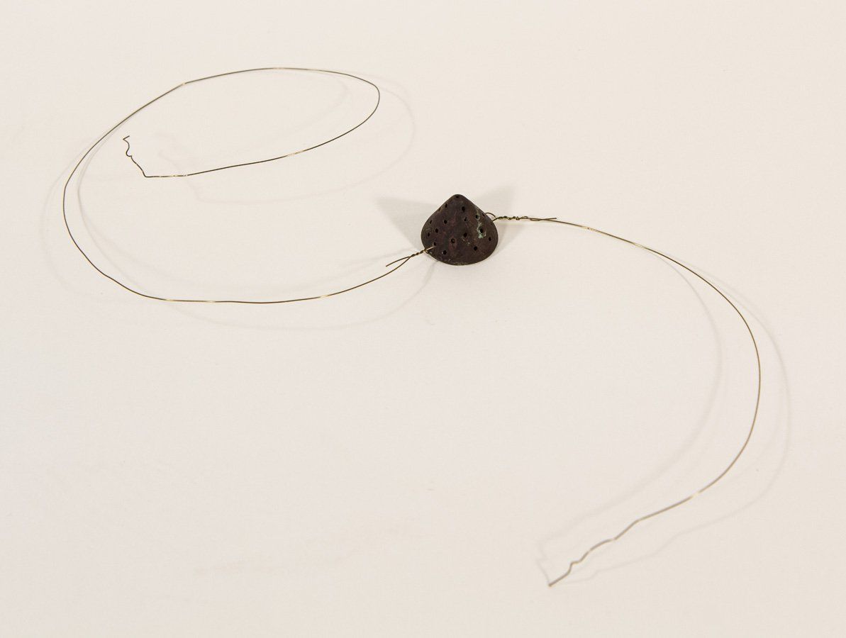 A necklace with a black bead on a chain