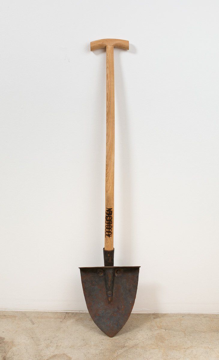 A shovel with a wooden handle is sitting on a table.