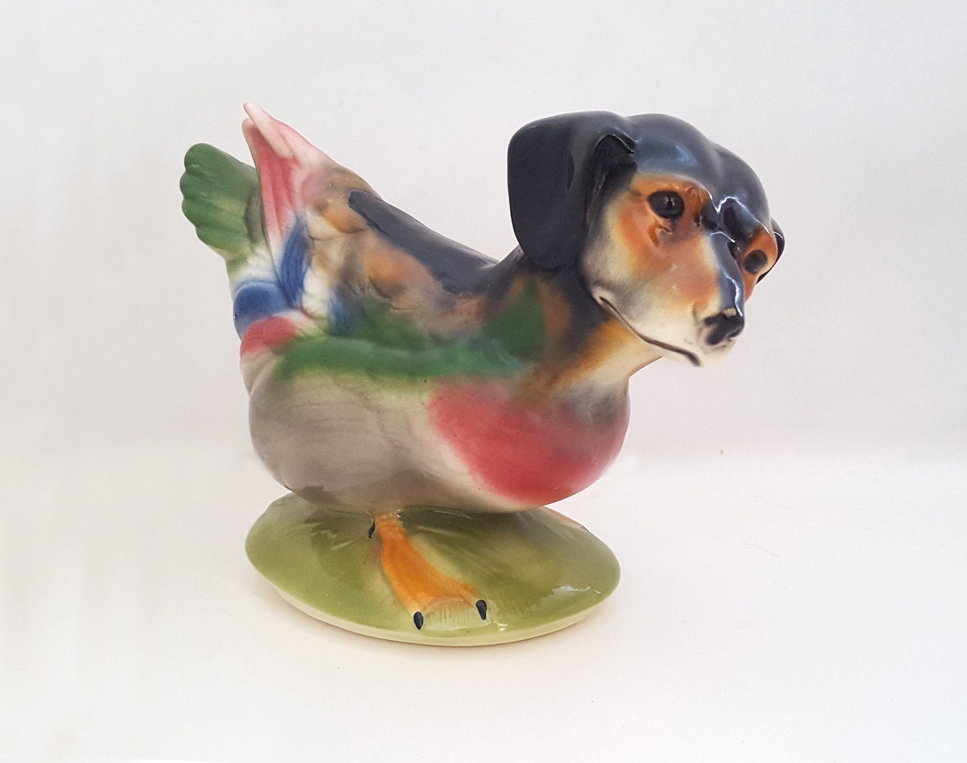 A statue of a duck with a dog 's head on it