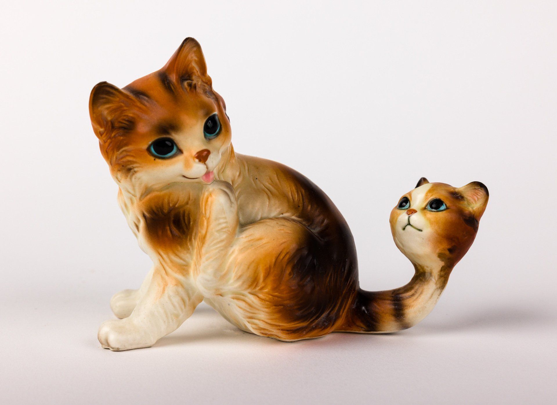 A figurine of a cat and a kitten on a white background