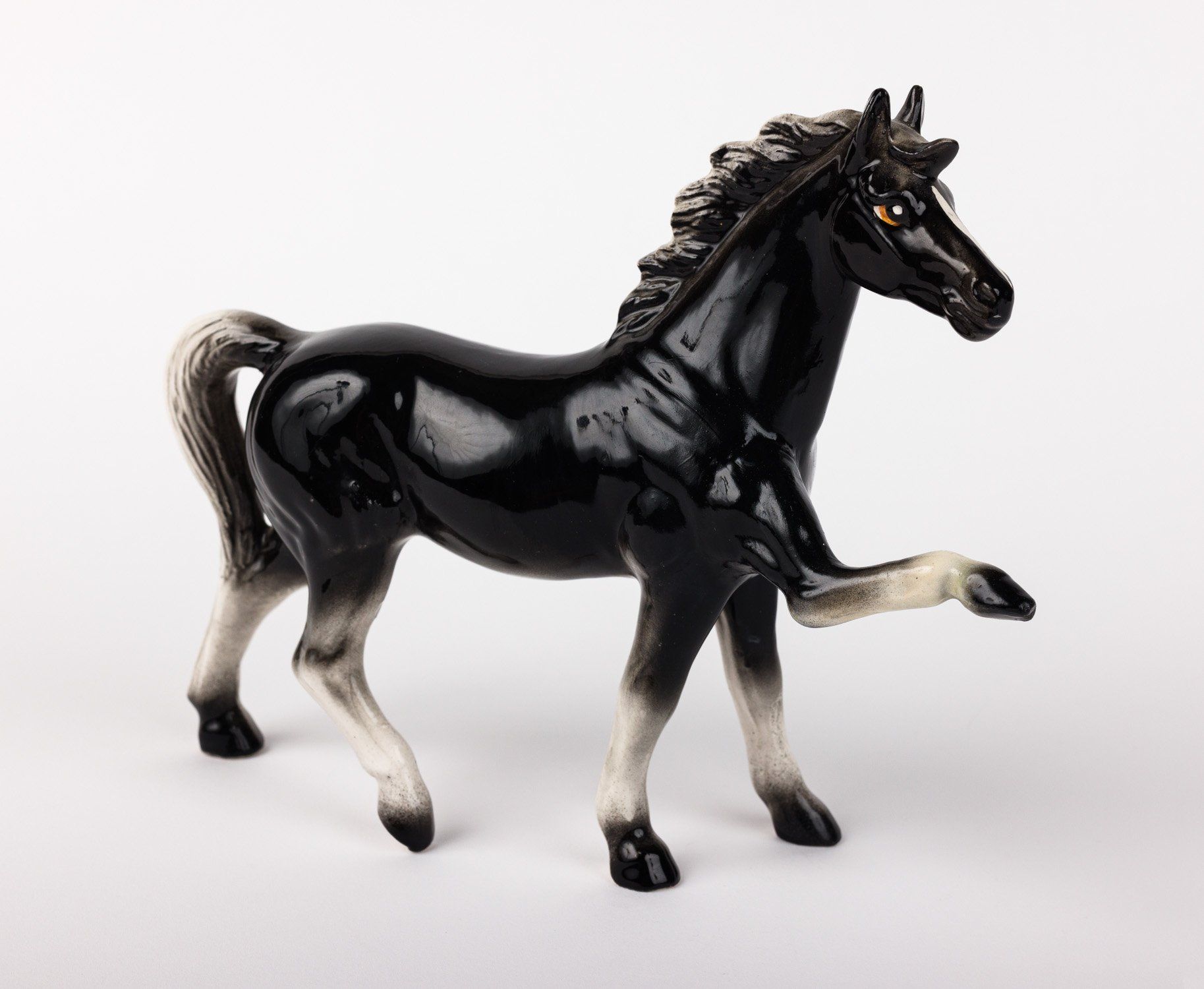 A black and white figurine of a horse standing on its hind legs