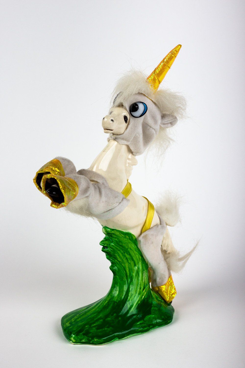 A stuffed animal in a unicorn costume is standing on its hind legs.