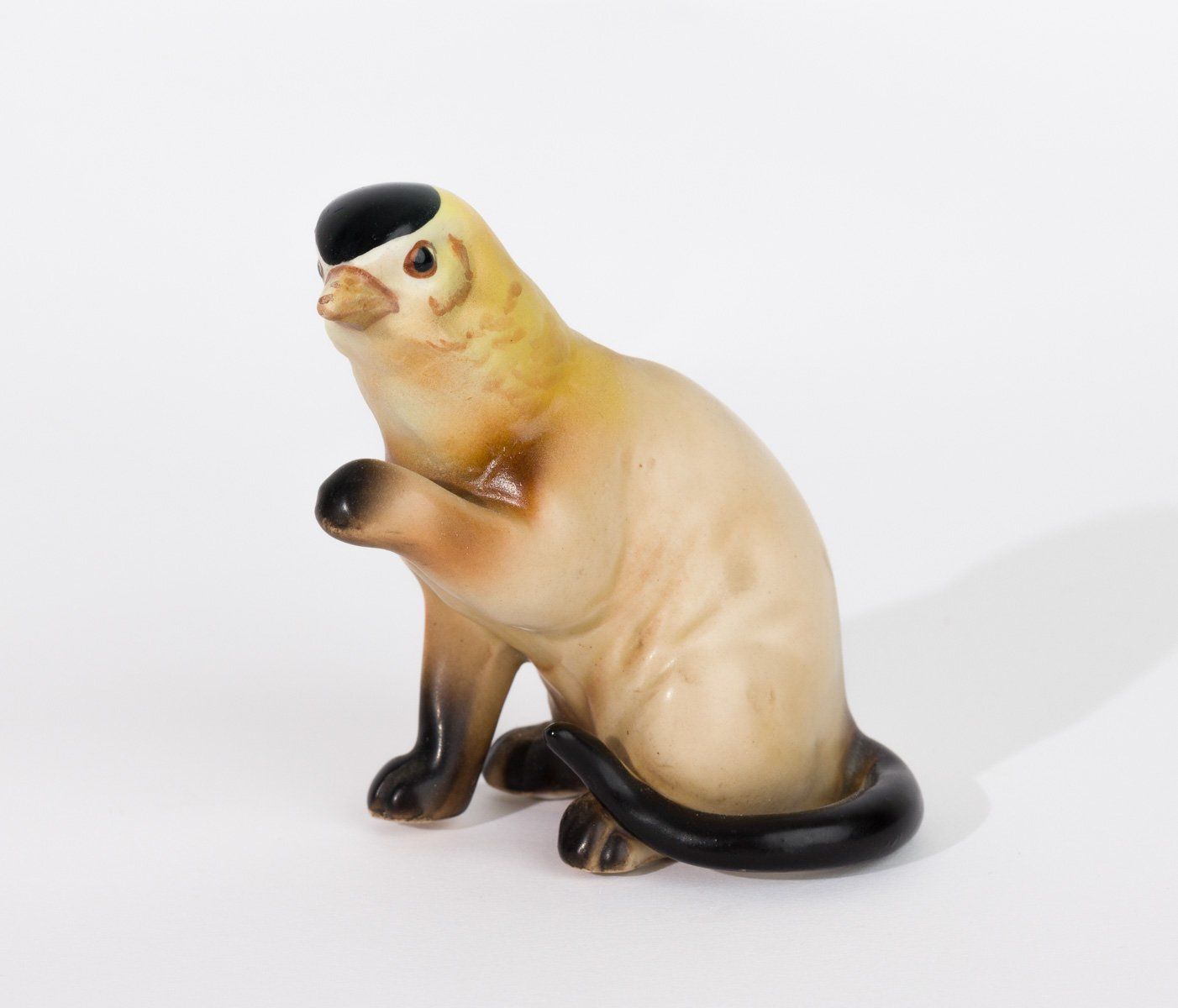 A statue of a cat with a bird on its head