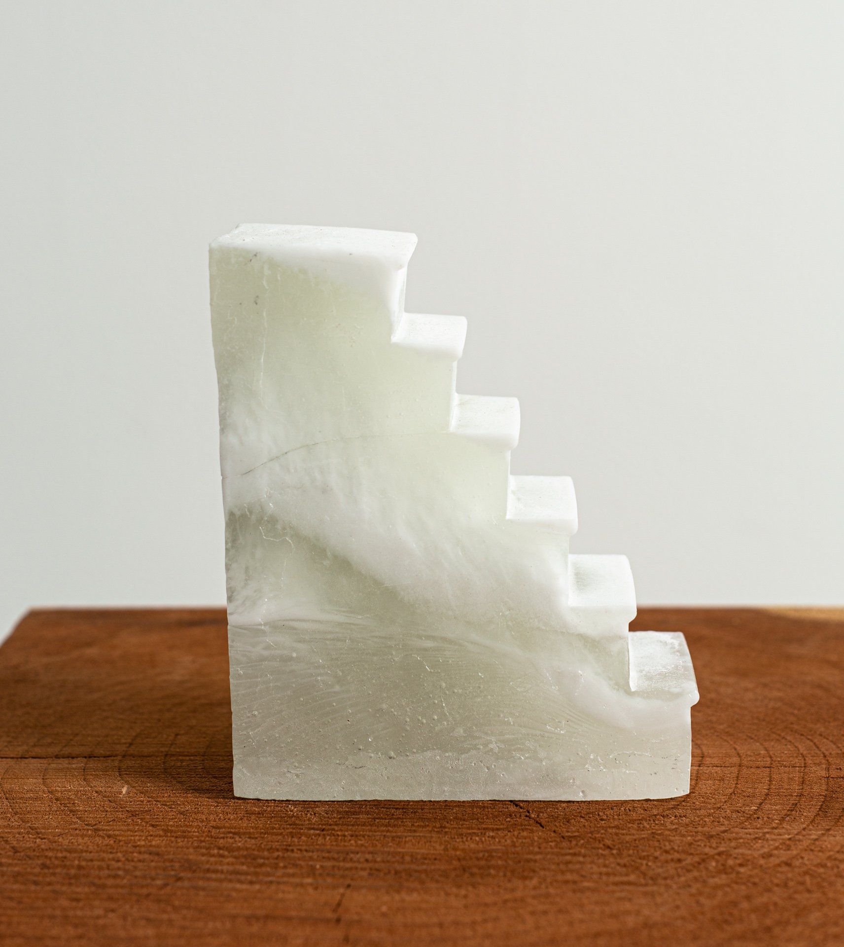 A white marble staircase is sitting on top of a wooden table.