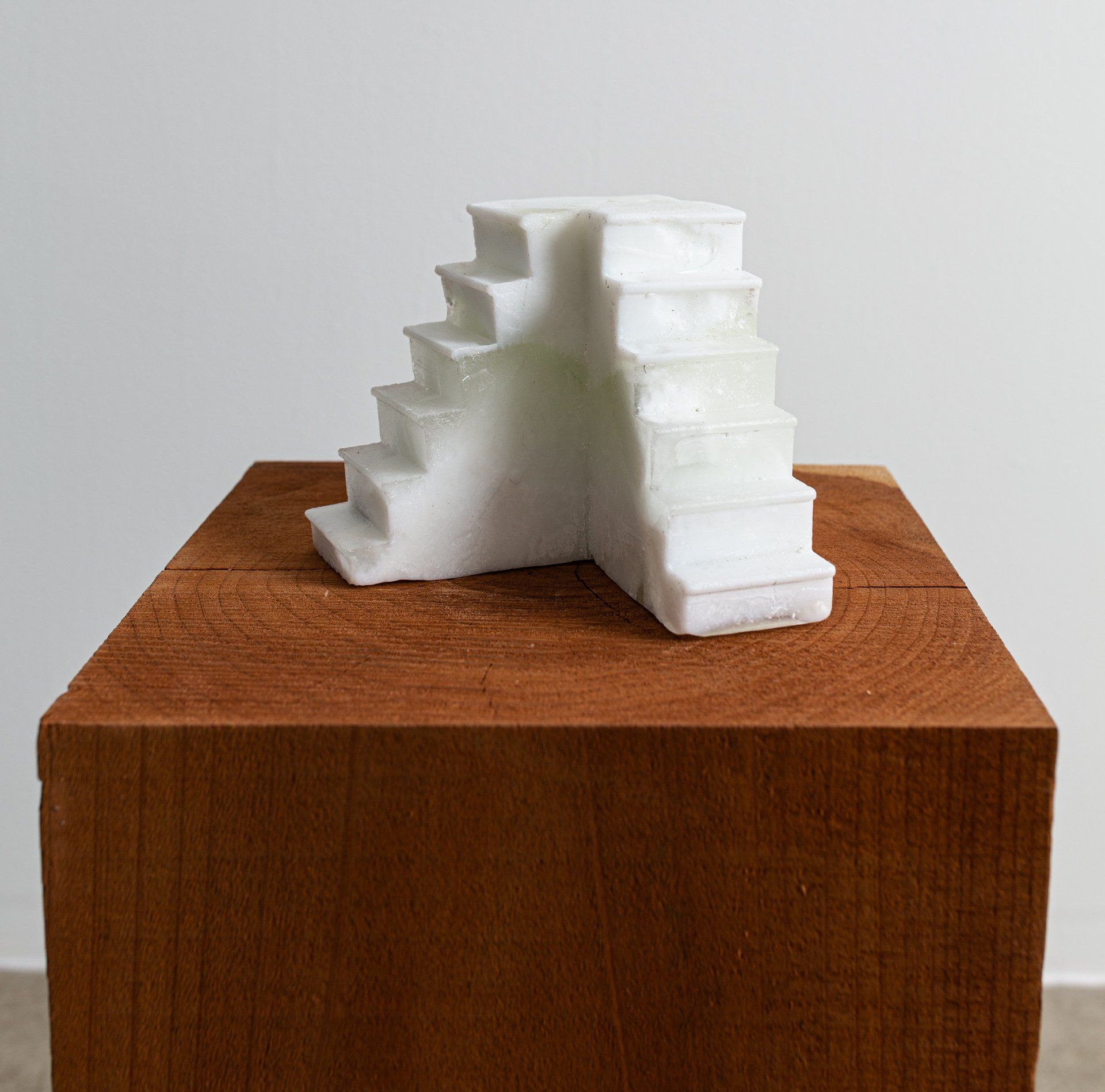 A white staircase is sitting on top of a wooden block