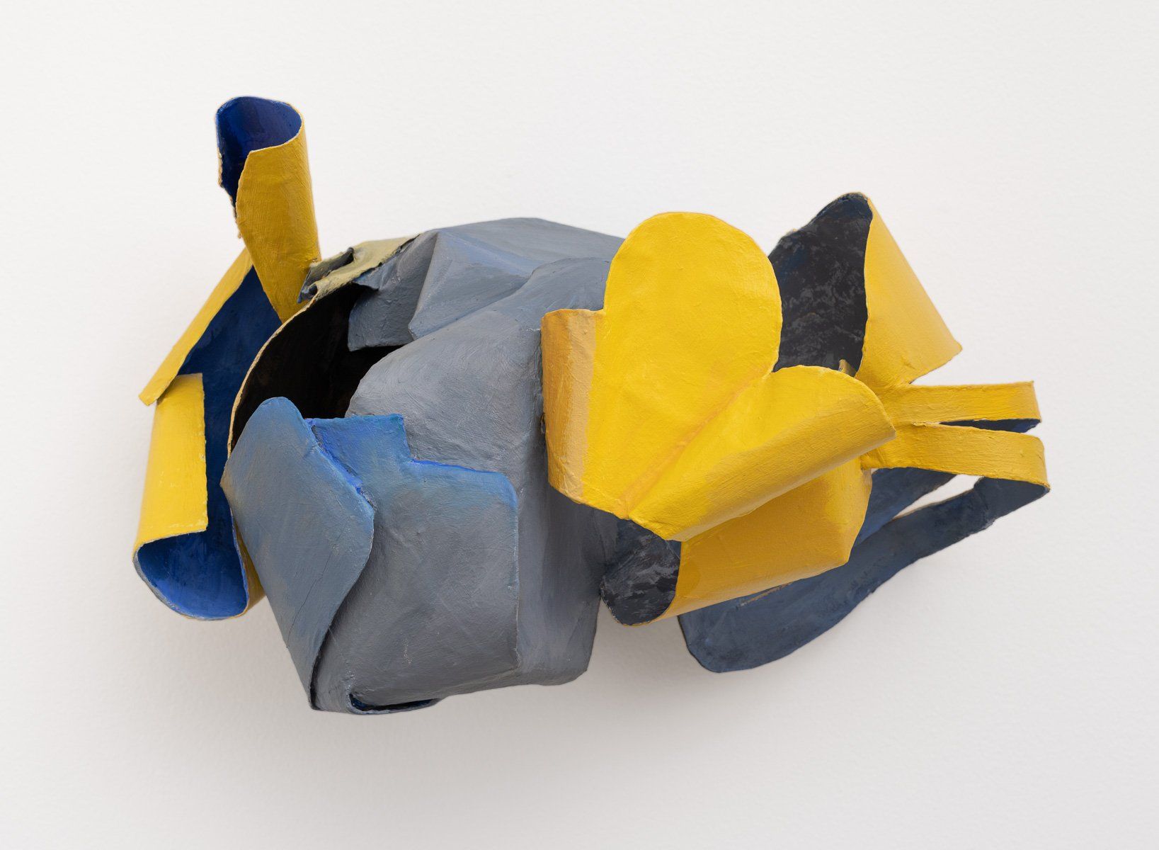 A blue and yellow sculpture on a white surface