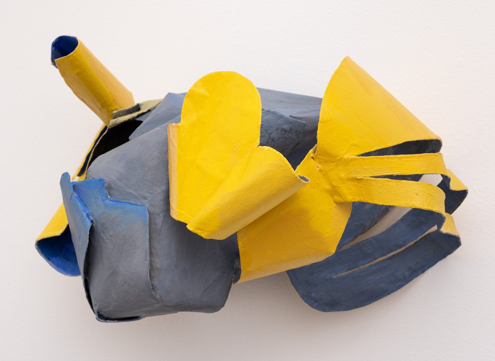 A yellow and blue object is sitting on a white surface.