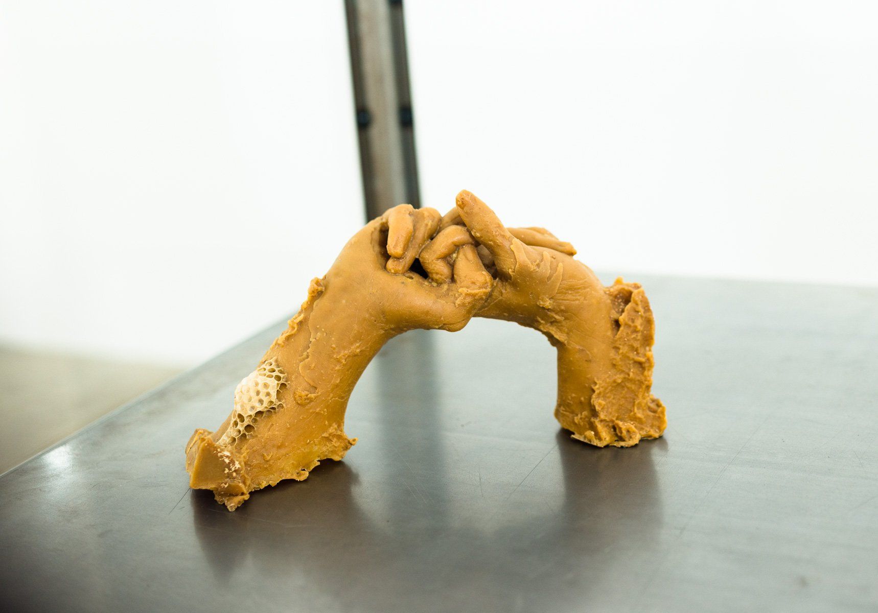 A sculpture of two hands holding each other on a table.