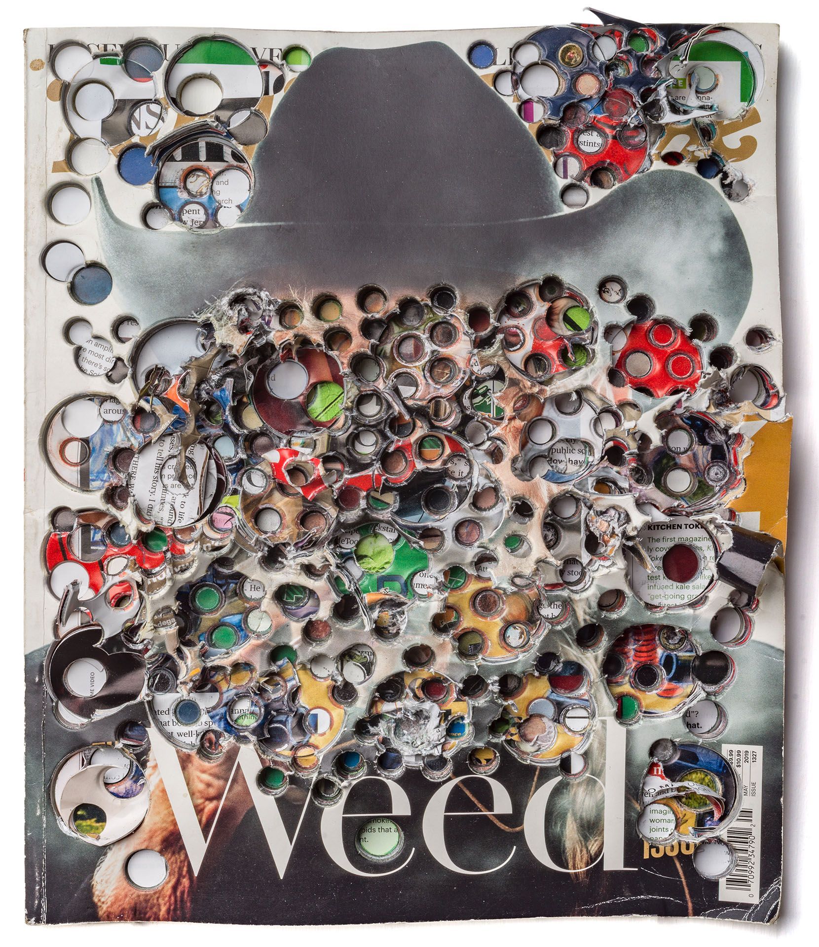 photograph of a man in a cowboy hat and the photograph has holes punched all through it.