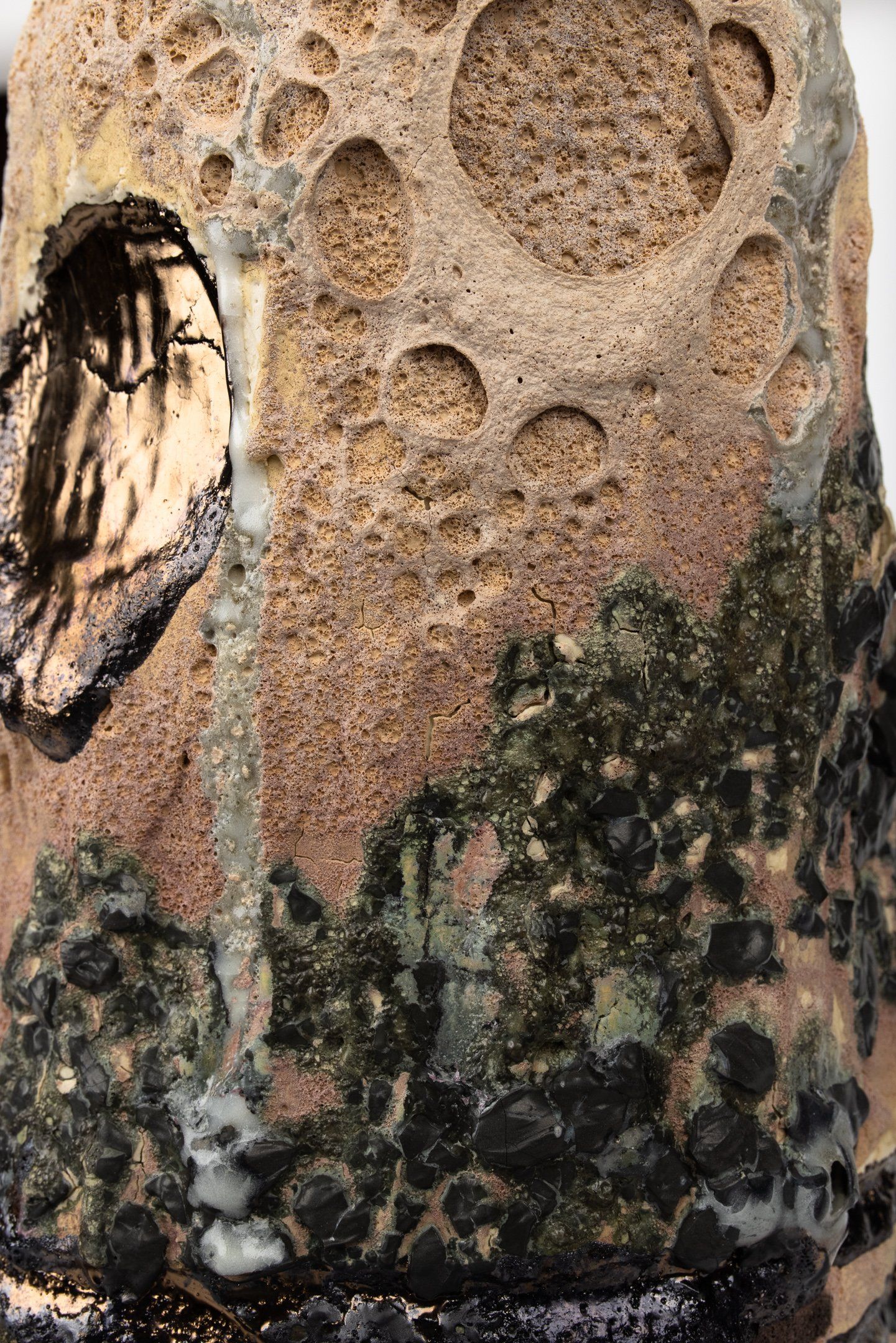 A close up of a ceramic vase with a skull on it.