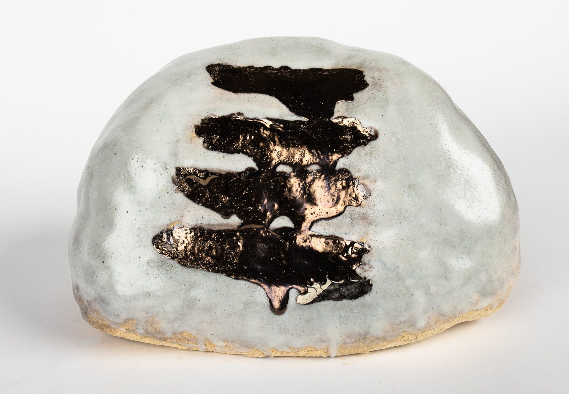 A white rock with a black and gold design on it