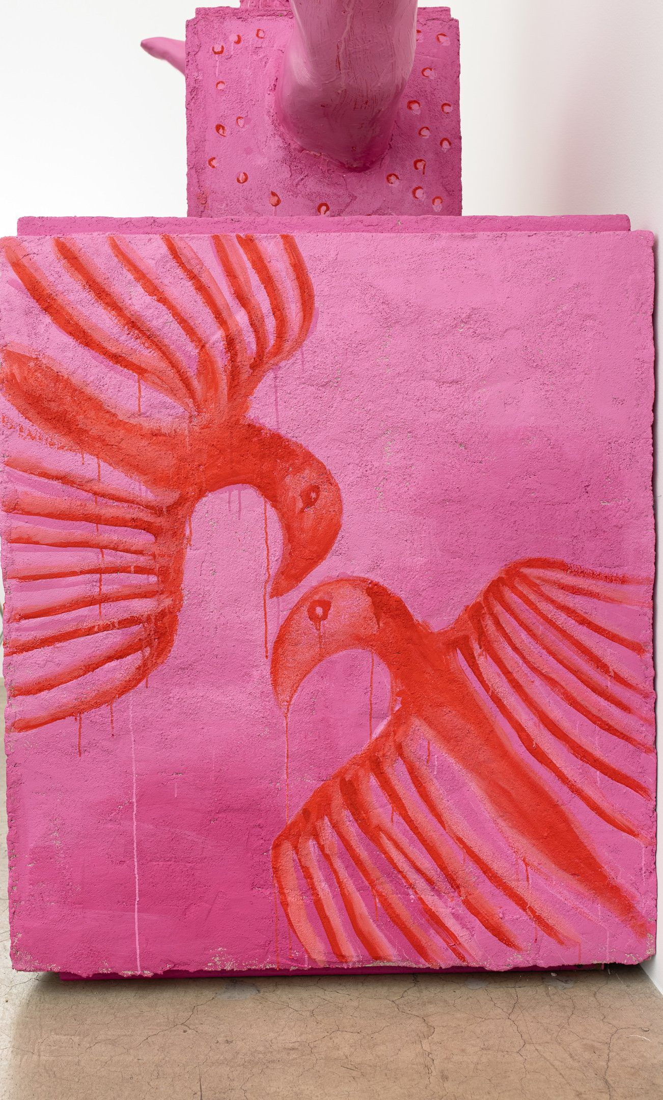 A pink square with two red birds on it.