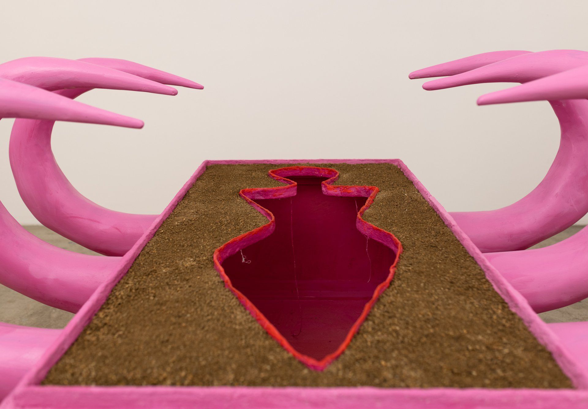 A pink statue with a heart in the middle of it