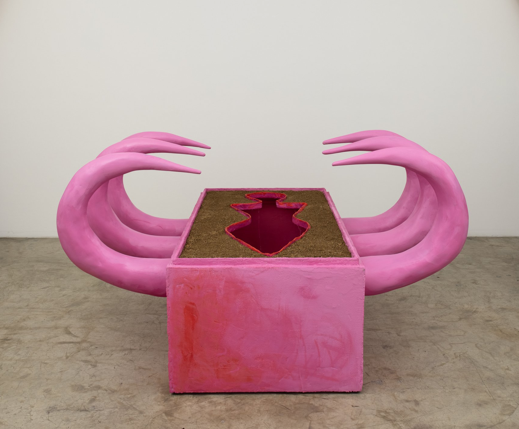 A pink sculpture with a hole in the middle of it