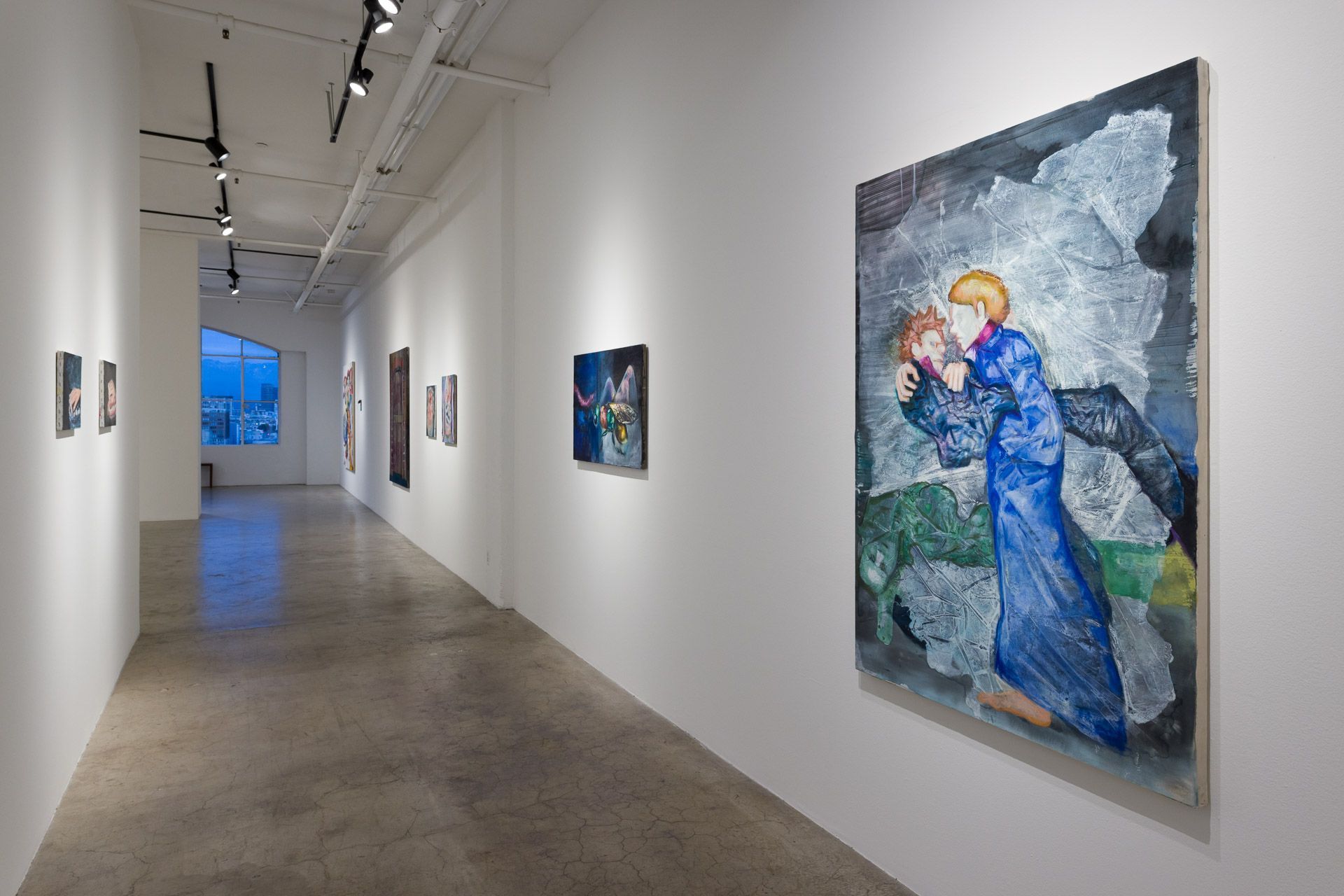 A long hallway with paintings on the wall and a large painting on the wall.