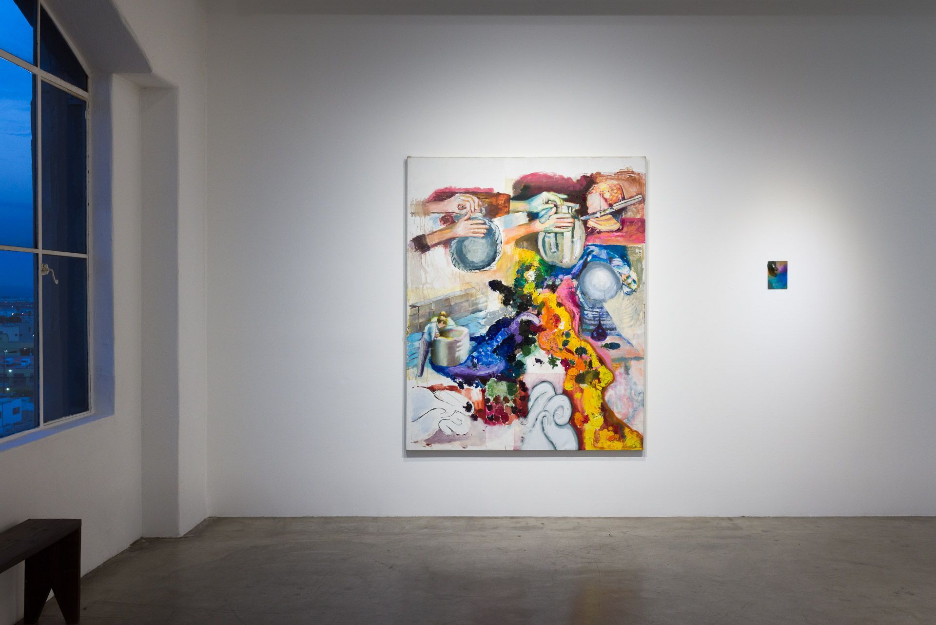 A room with a painting on the wall and a window.
