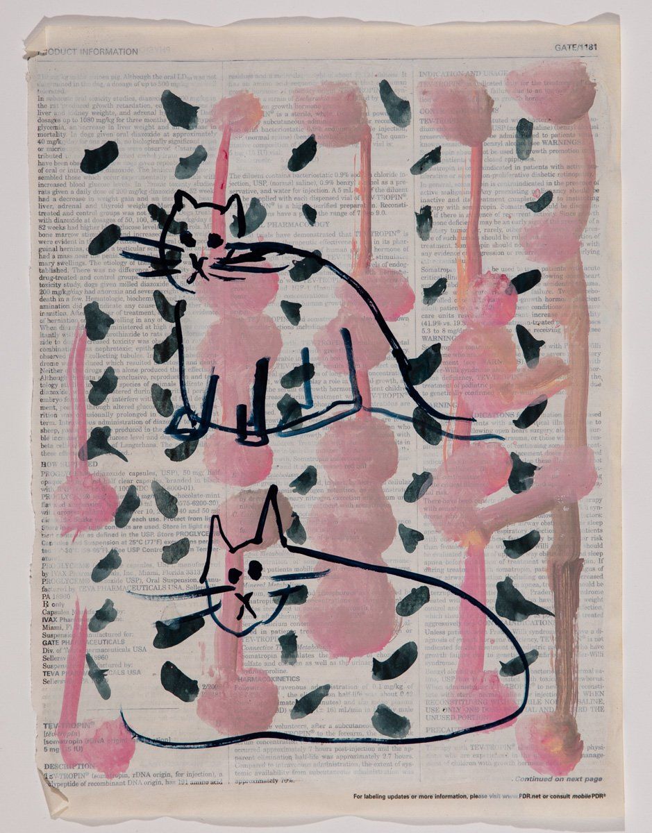 A painting of two cats on a page of a book