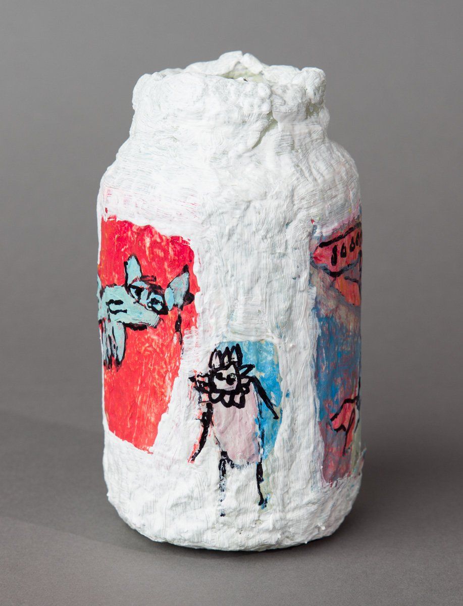 A white jar with a drawing of a cat on it