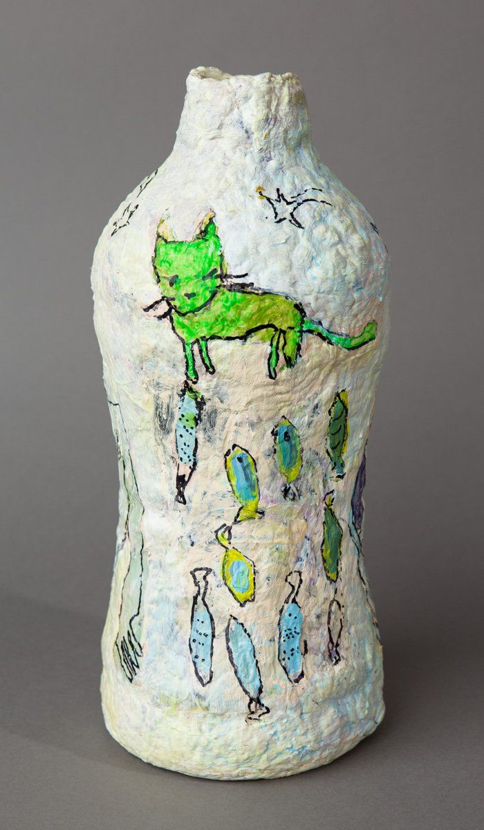 A vase with a green cat and fish painted on it.