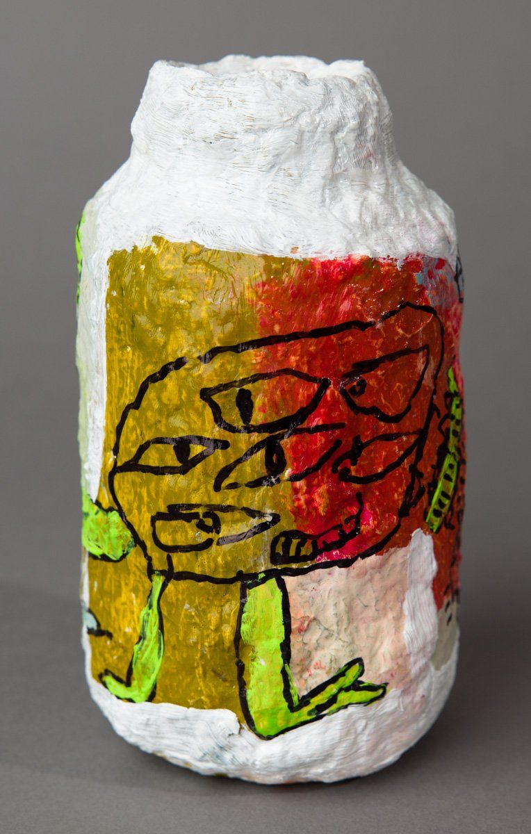 A white bottle with a drawing of a frog on it.