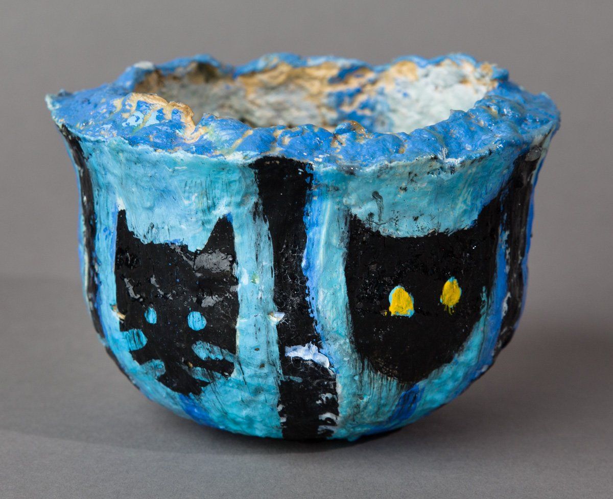 A blue bowl with two black cats painted on it