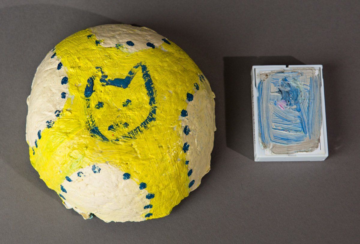 A yellow and white ball with a picture of a cat on it