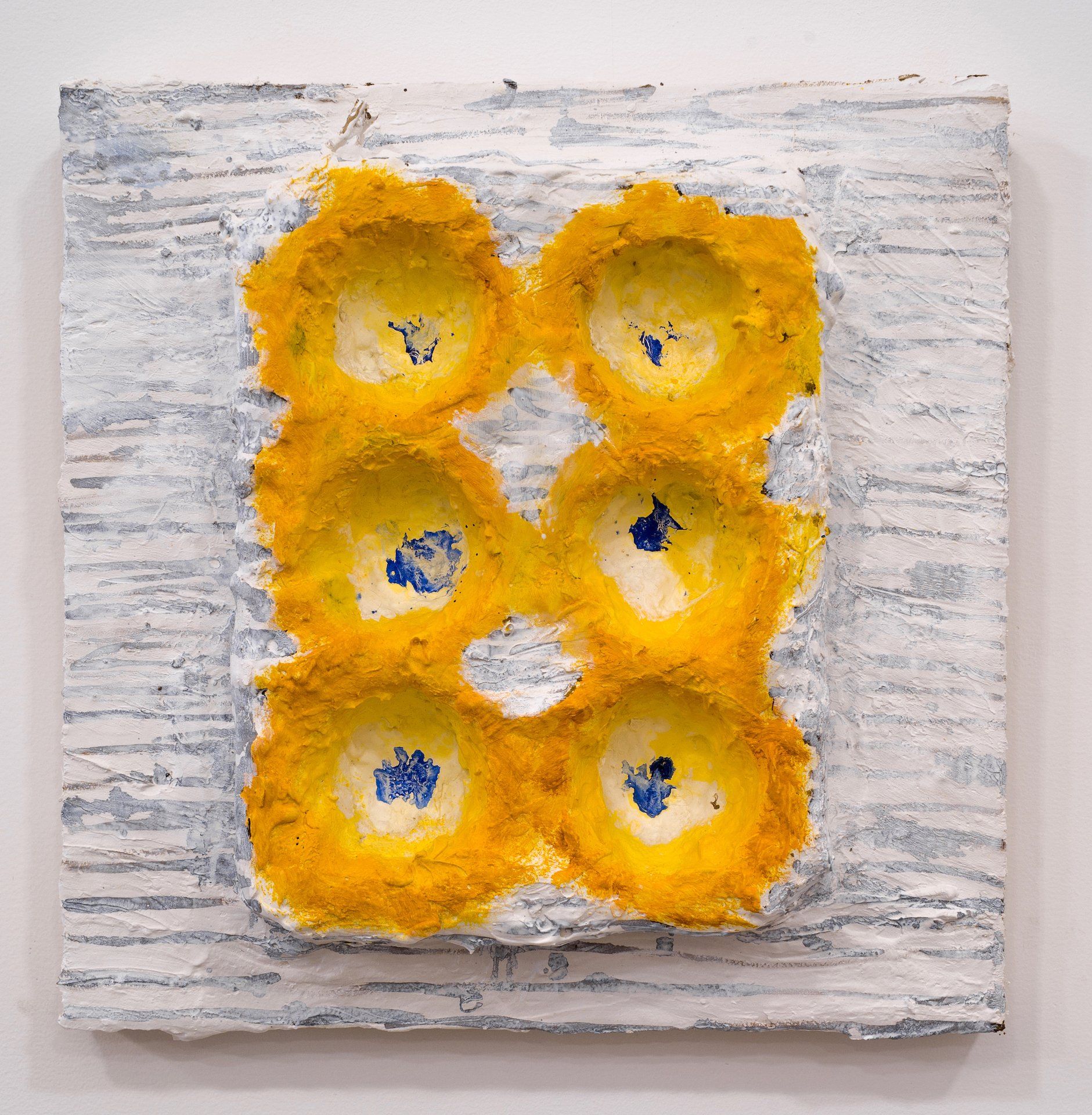 A painting of yellow circles on a white surface.
