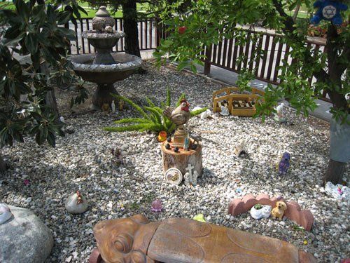 A gravel garden with a statue of a turtle and a fountain
