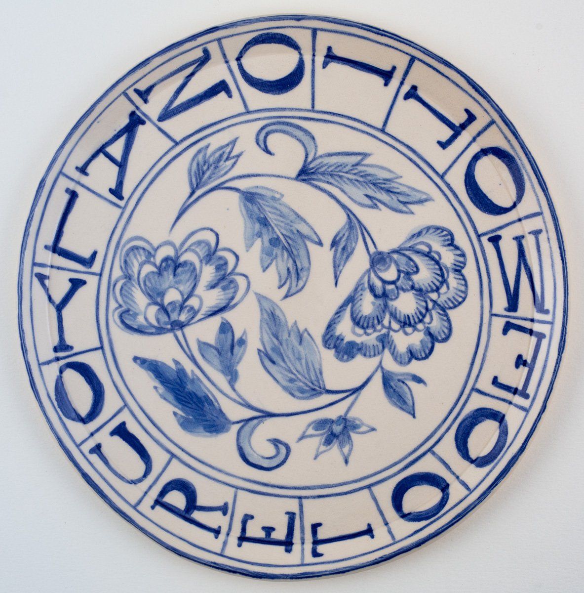 A blue and white plate with flowers and the words