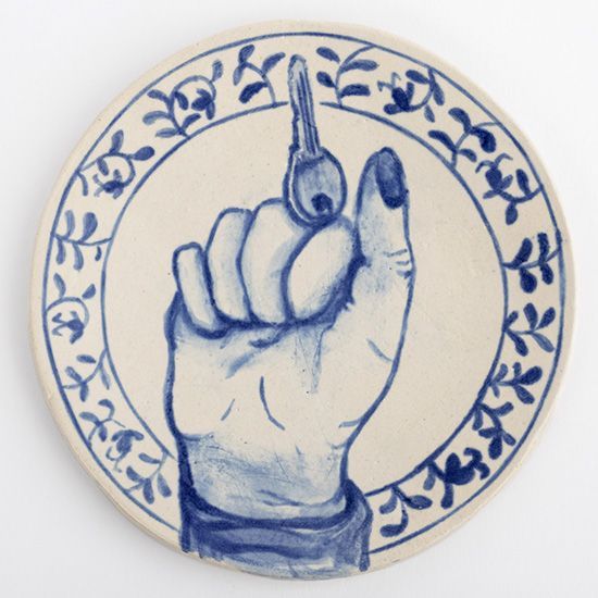 A blue and white plate with a hand holding a key