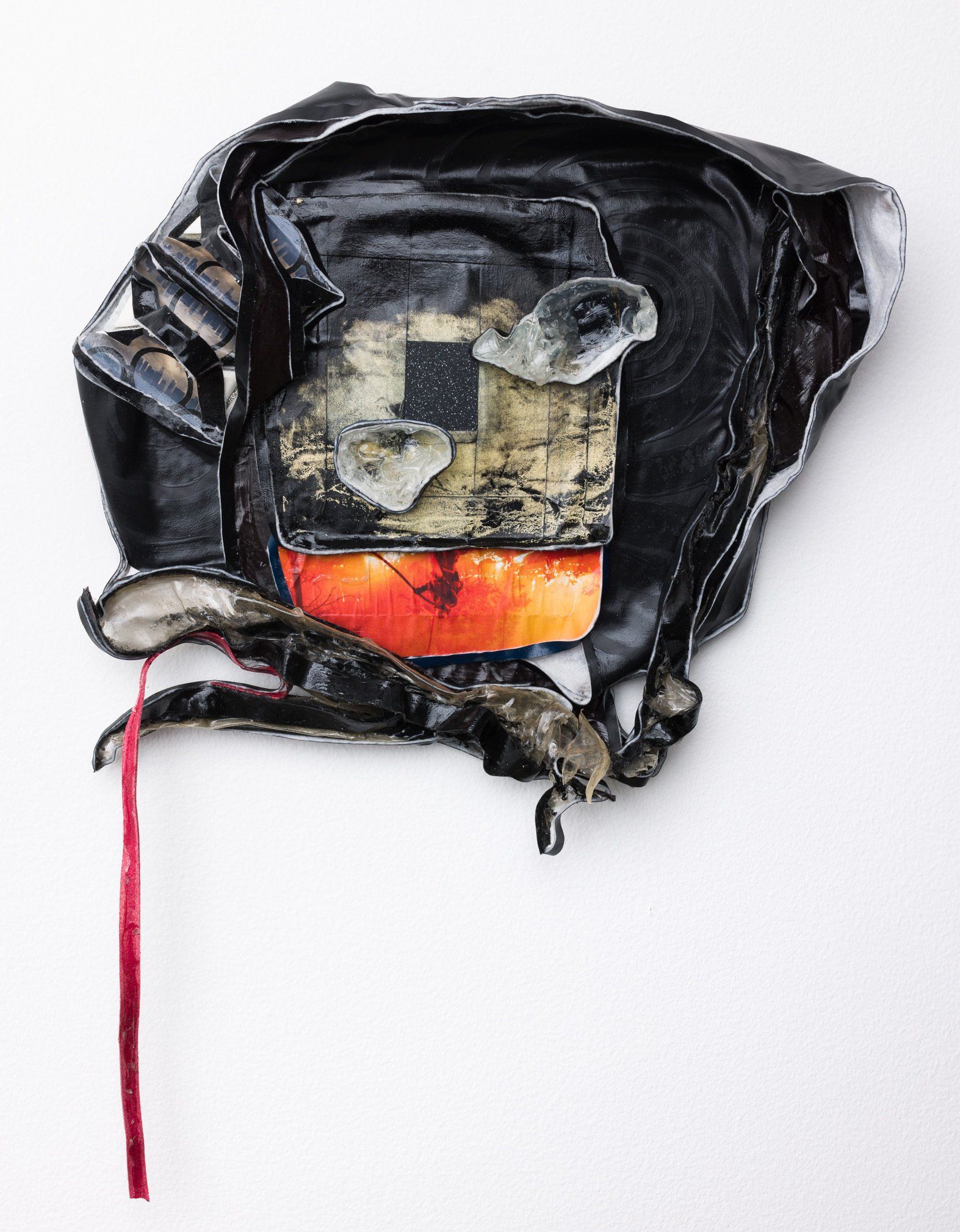 A piece of black leather with a red ribbon around it