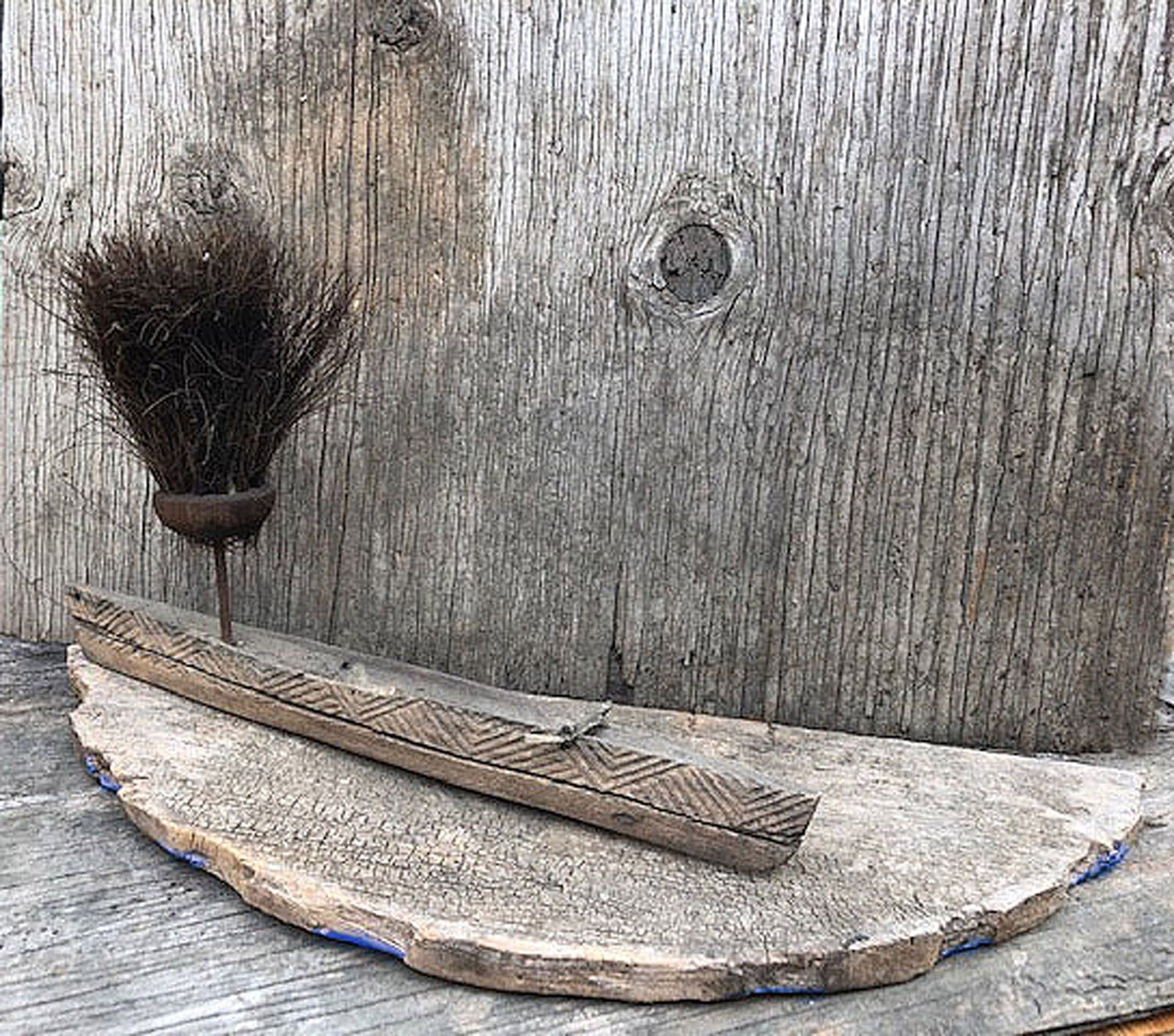A broom and a brush are sitting on a wooden table.