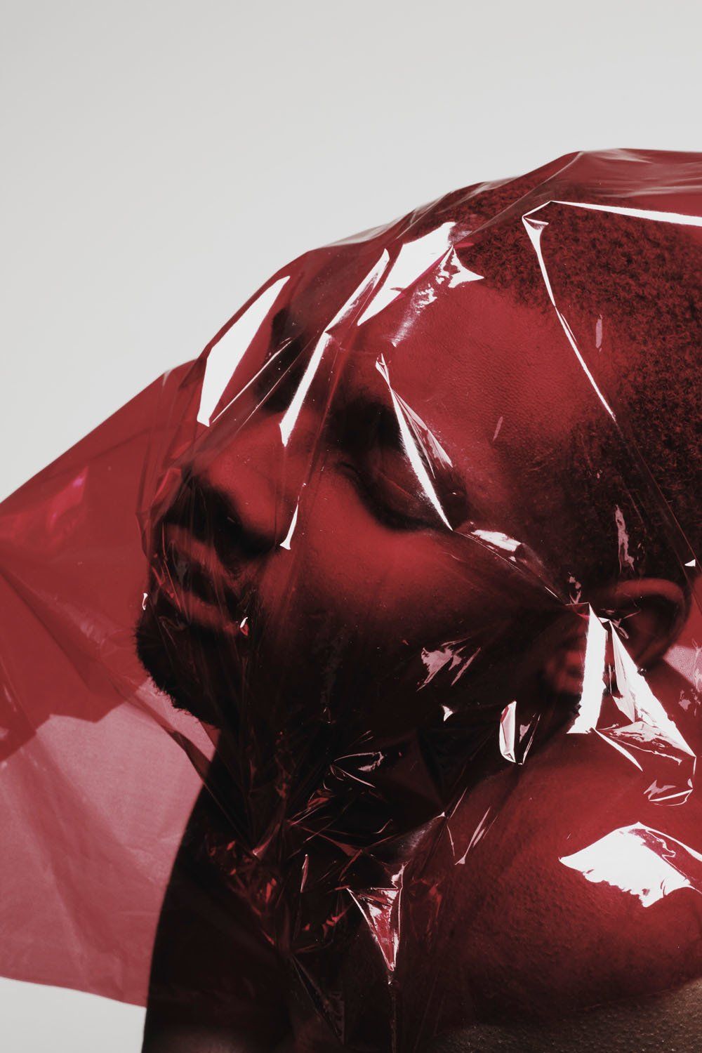 A close up of a man wrapped in red plastic