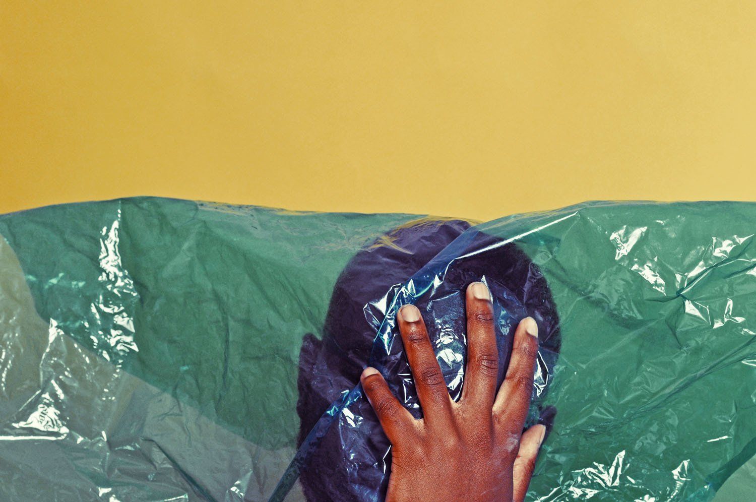 A person is covering their face with a plastic bag.