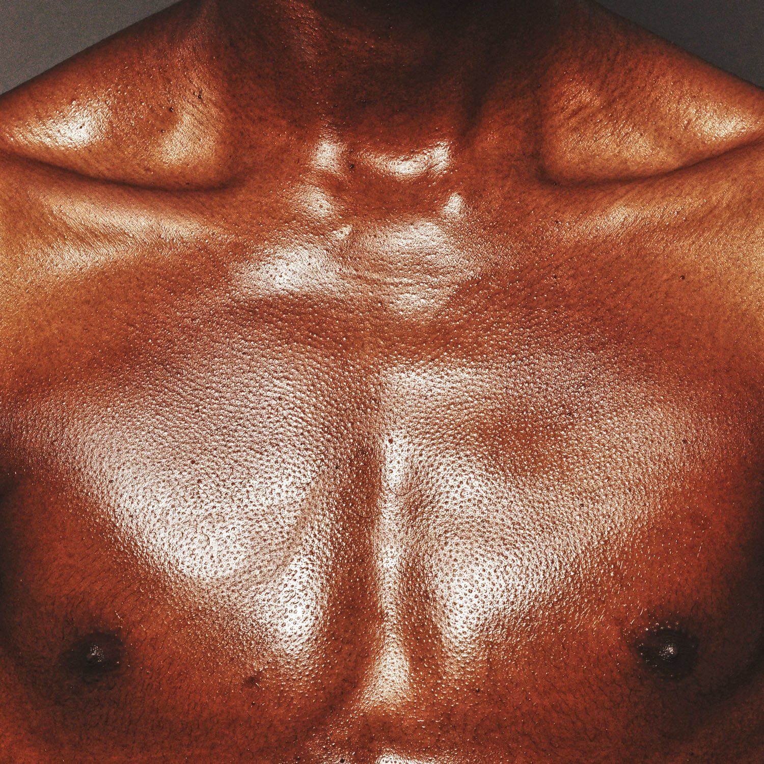 A close up of a man 's chest and shoulder